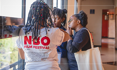 Two people in conversation at the festival, one wearing an NBO Film Festival shirt